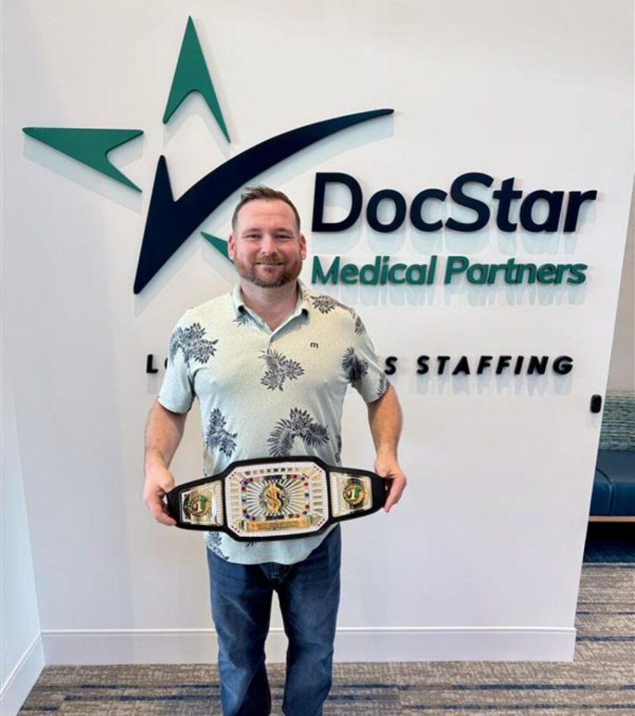 Man holding championship belt at DocStar.